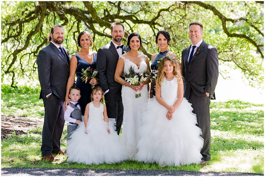 Bride and groom with family at The Vineyards at Chappel Lodge.  Bride wearing dress from Alexia Gavela Bridal and groom wearing suit from Men's Wearhouse.  Bride holding bouquet from Exquisite Petals.