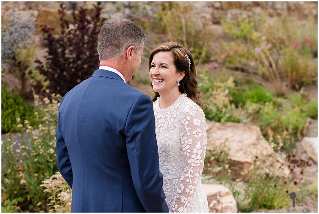 Bride smiling at groom during first look at Betty Ford Alpine Gardens in Vail for micro wedding.