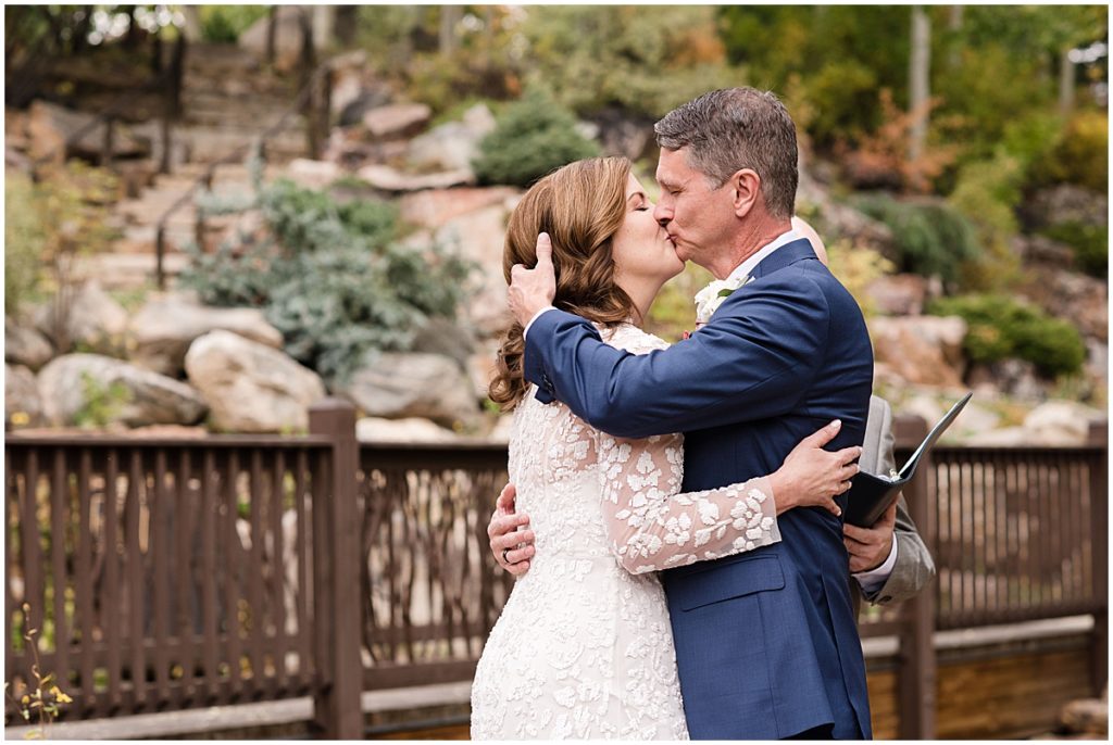 Bride and groom kiss during ceremony at at Betty Ford Alpine Gardens in Vail for micro wedding.  