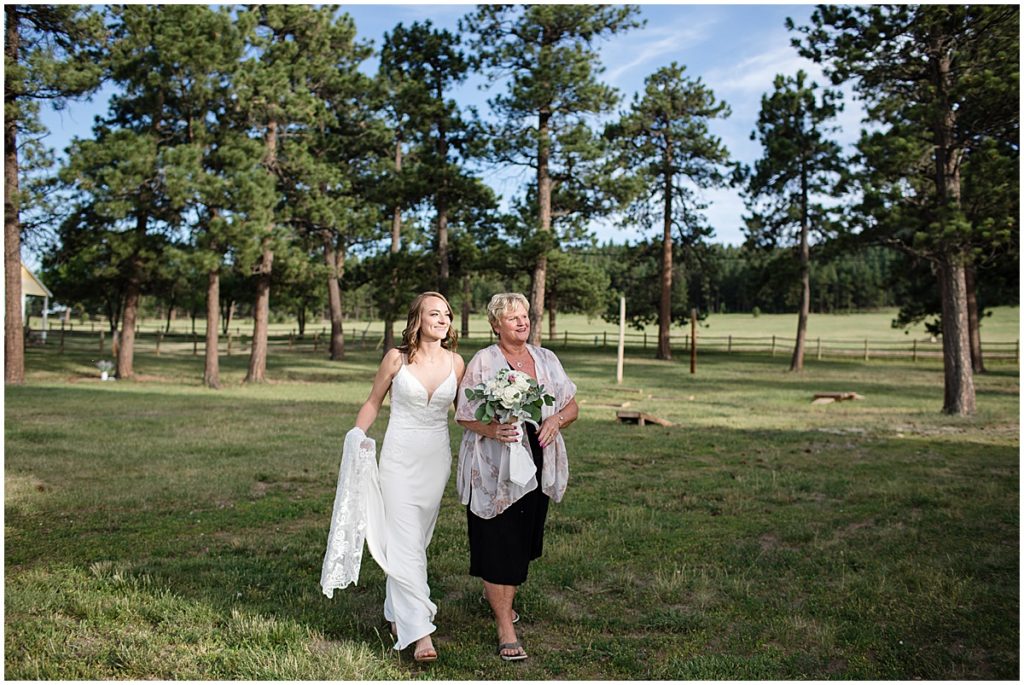 Bride walking with mom outside for elopement at Three Sisters Park in Evergreen