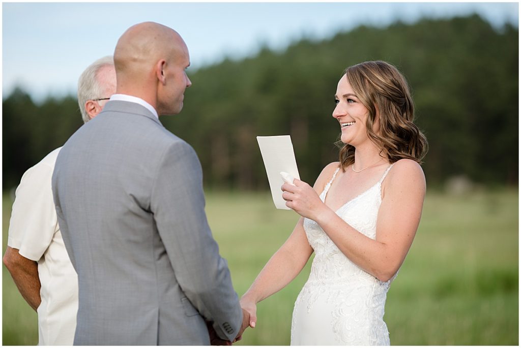 Bride and groom reading vows outside during elopement at Three Sisters Park in Evergreen