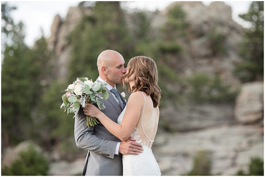 Bride and groom hugging and kissing outside after elopement at Three Sisters Park in Evergreen