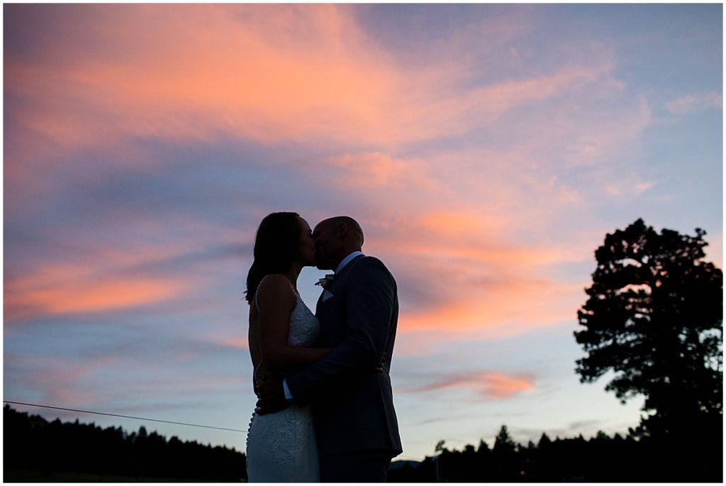 Bride and groom kissing at sunset after elopement at Three Sisters Park in Evergreen
