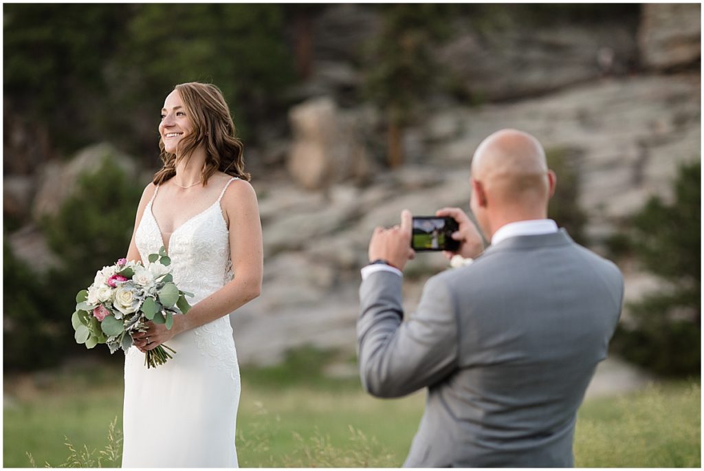 Groom taking picture of bride with his camera at Three Sisters Park
