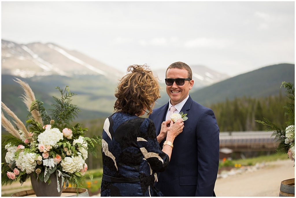 Mom putting on boutonniere on son for wedding at 10 mile station in Breckenridge