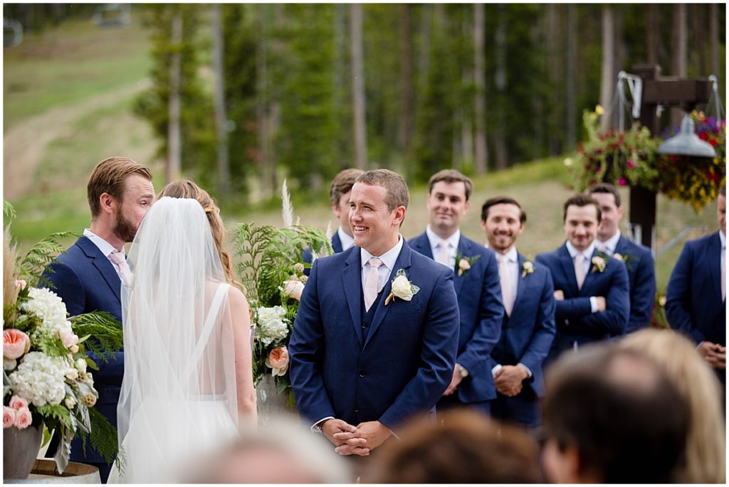 Groom laughing with bride during  wedding ceremony at 10 mile station in Breckenridge