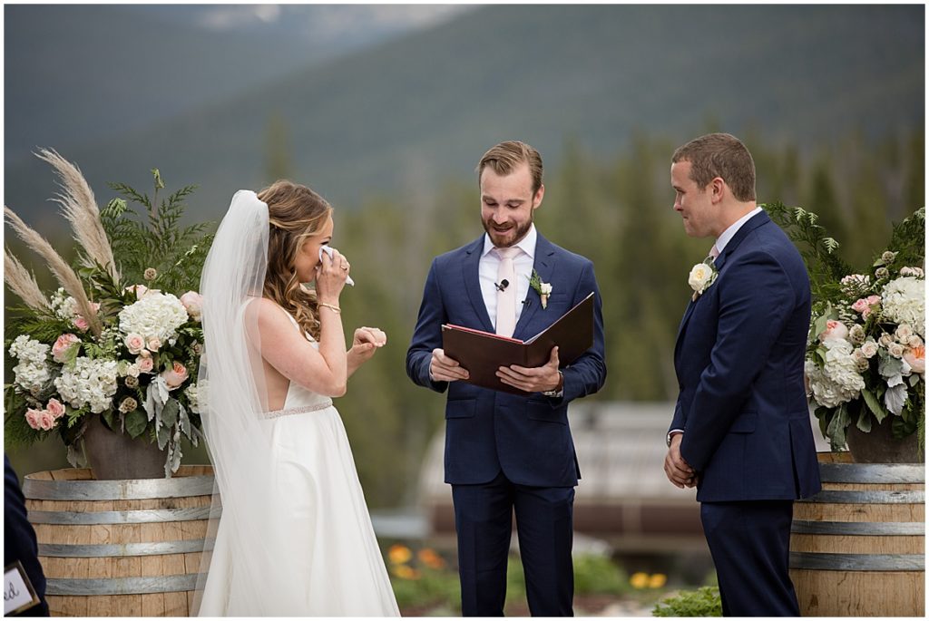 Bride wiping tear during wedding ceremony at 10 mile station in Breckenridge