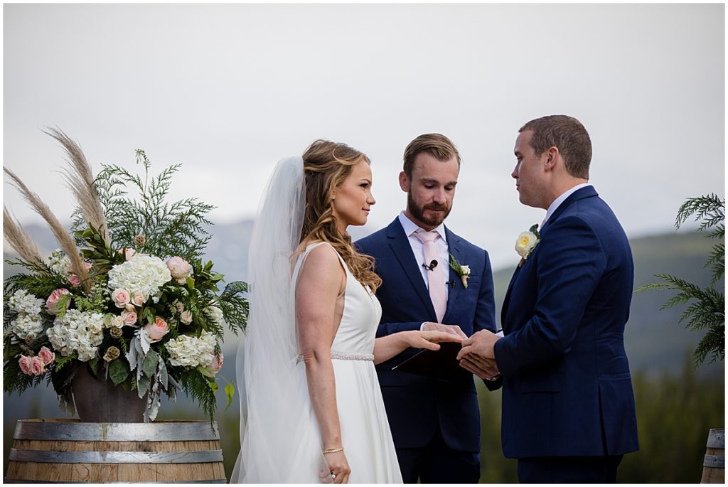 Bride and groom exchanging rings during ceremony at 10 mile station in Breckenridge