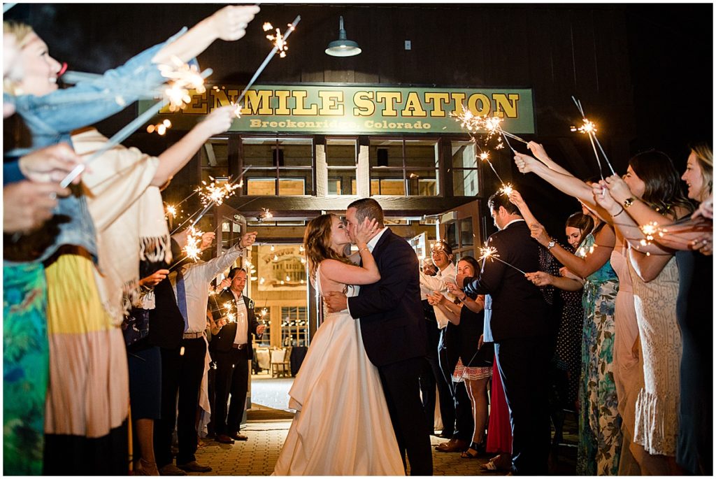 Bride and groom exiting 10 Mile Station as guests are holding sparklers