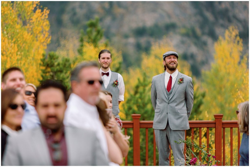 Groom waiting for Bride to walk down aisle at Frisco Day Lodge. Groom wearing suit from Jim's Formal Wear.