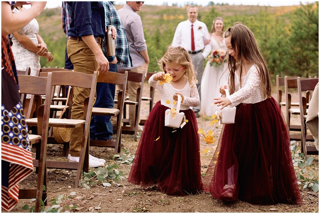 Flower girls spreading petals in front of bride for wedding at Frisco Day Lodge