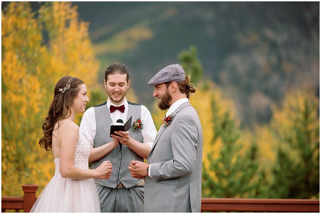 Officiant speaking to bride and groom  during wedding ceremony at Frisco Day Lodge