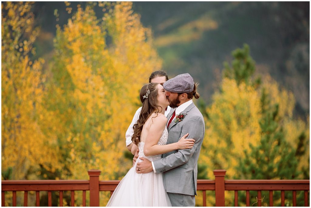 Bride and groom kiss at end of wedding ceremony at Frisco Day Lodge