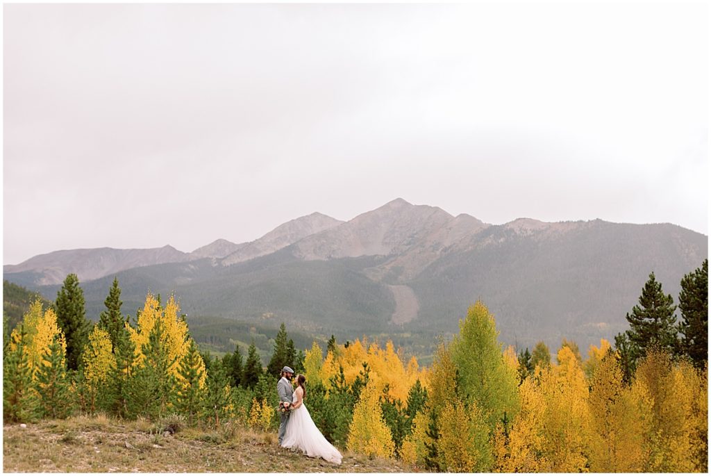 Bride and groom walking through aspen trees after wedding ceremony at Frisco Day Lodge