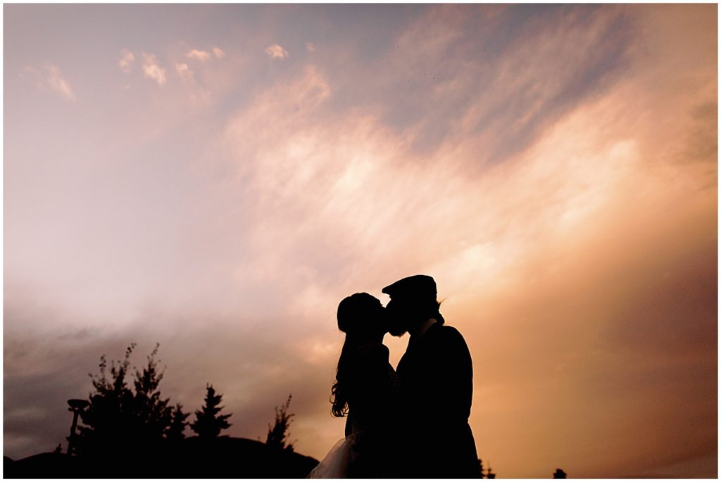Bride and groom kiss during wedding reception sunset at Frisco Day Lodge in the Fall