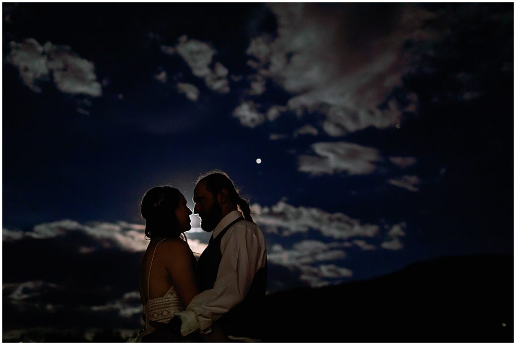 Bride and groom kiss during reception late evening at Frisco Day Lodge 