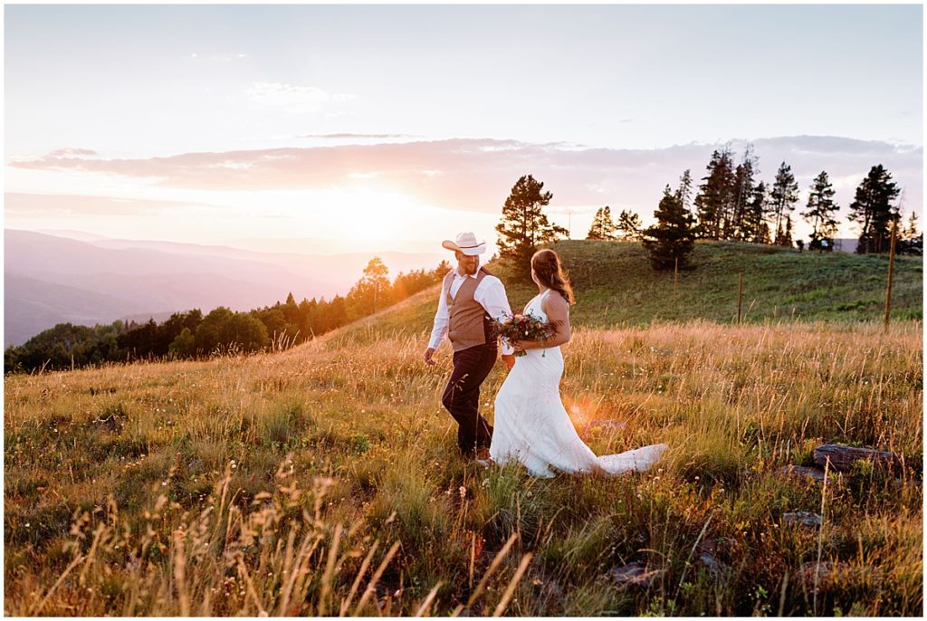 Bride and groom walking on field at Holy Cross Overlook in Vail