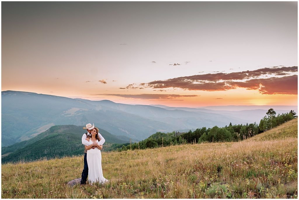 Bride and groom embracing at top of  Holy Cross Overlook in Vail