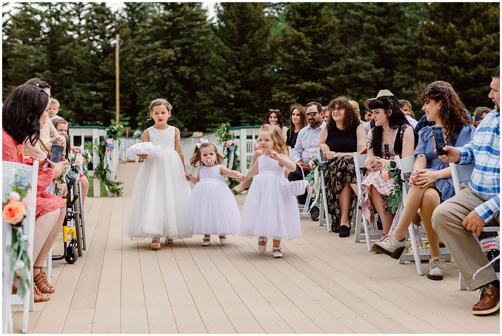 Flower girls walking down isle for ceremony at Deer Creek Valley Ranch