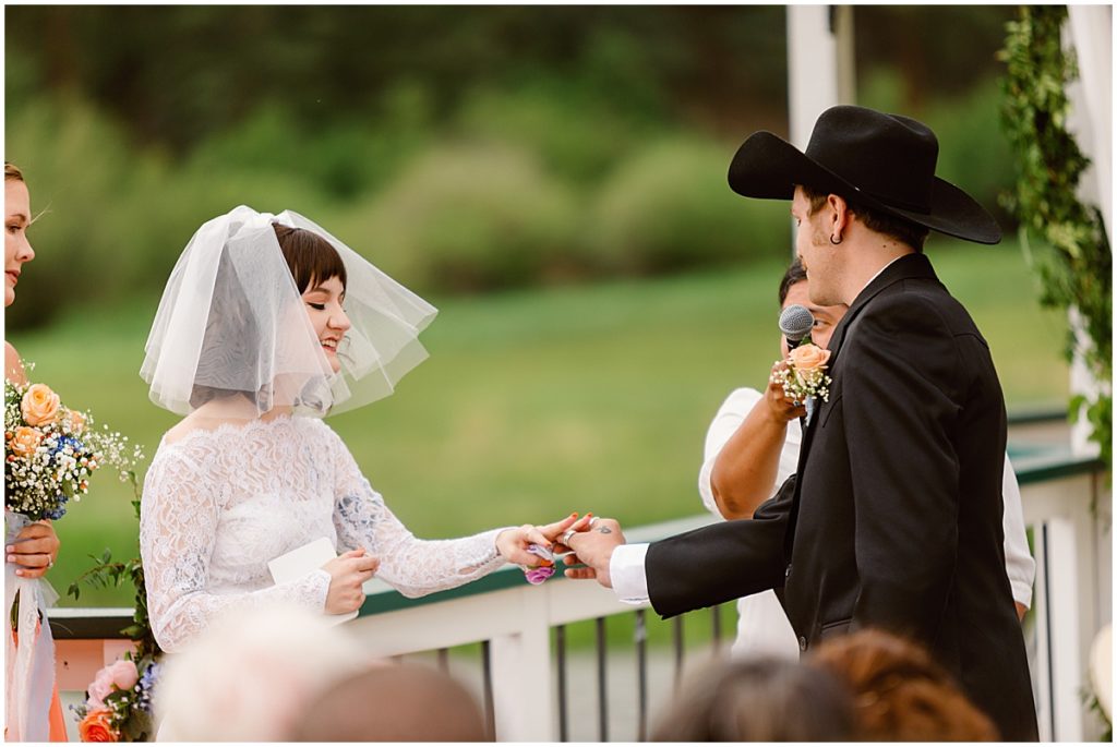 Bride and groom exchanging rings at Deer Creek Valley Ranch
