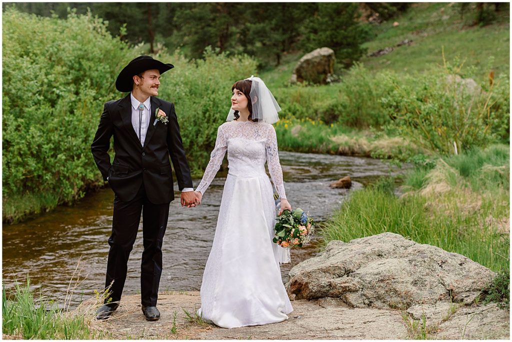 Bride and groom walking by water stream at Deer Creek Valley Ranch