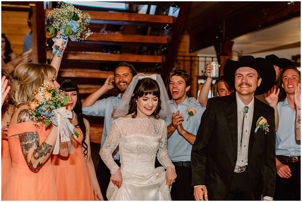 Bride and groom with wedding party in barn at Deer Creek Valley Ranch