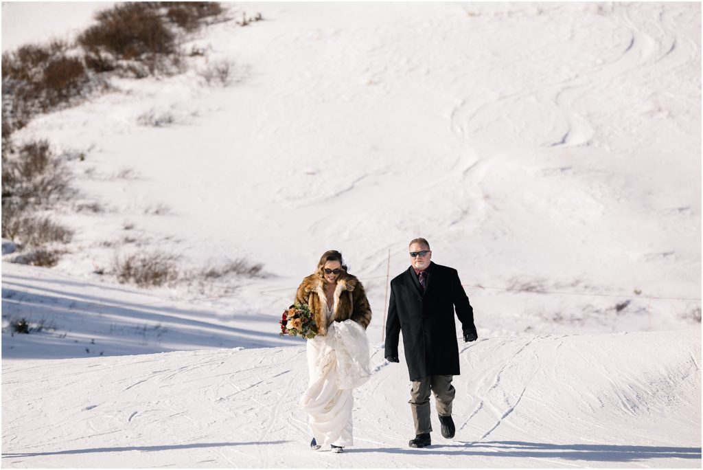 Father and bride walking up hill at Arapahoe Basin before wedding
