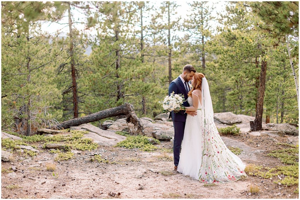 First look with bride wearing dress from BHLDN and designed by Watters for fall elopement at Blue Sky Mountain Ranch in Blackhawk.  Groom is a wearing suit from Indochino.  Bride holding bouquet designed by Blush & Bay.