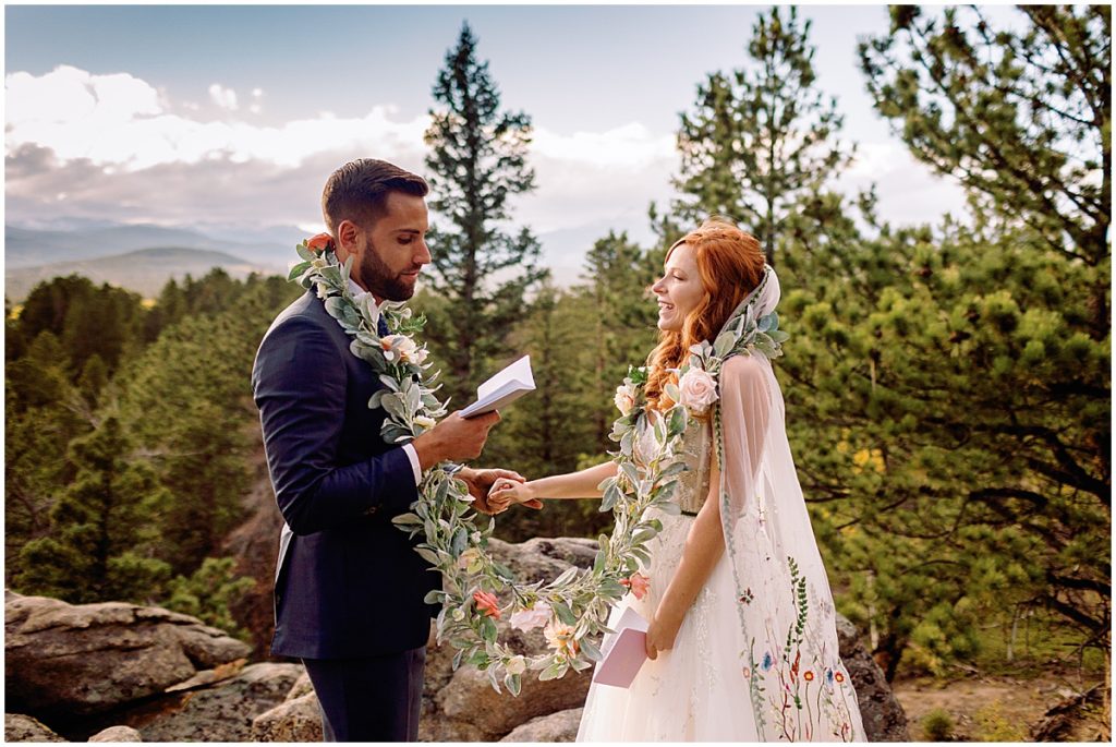 Elopement ceremony at Blue Sky Mountain Ranch in Blackhawk with bride wearing dress from BHLDN and designed by Watters.  Groom is reading vows and wearing suit from Indochino.  Floral design by Blush & Bay.