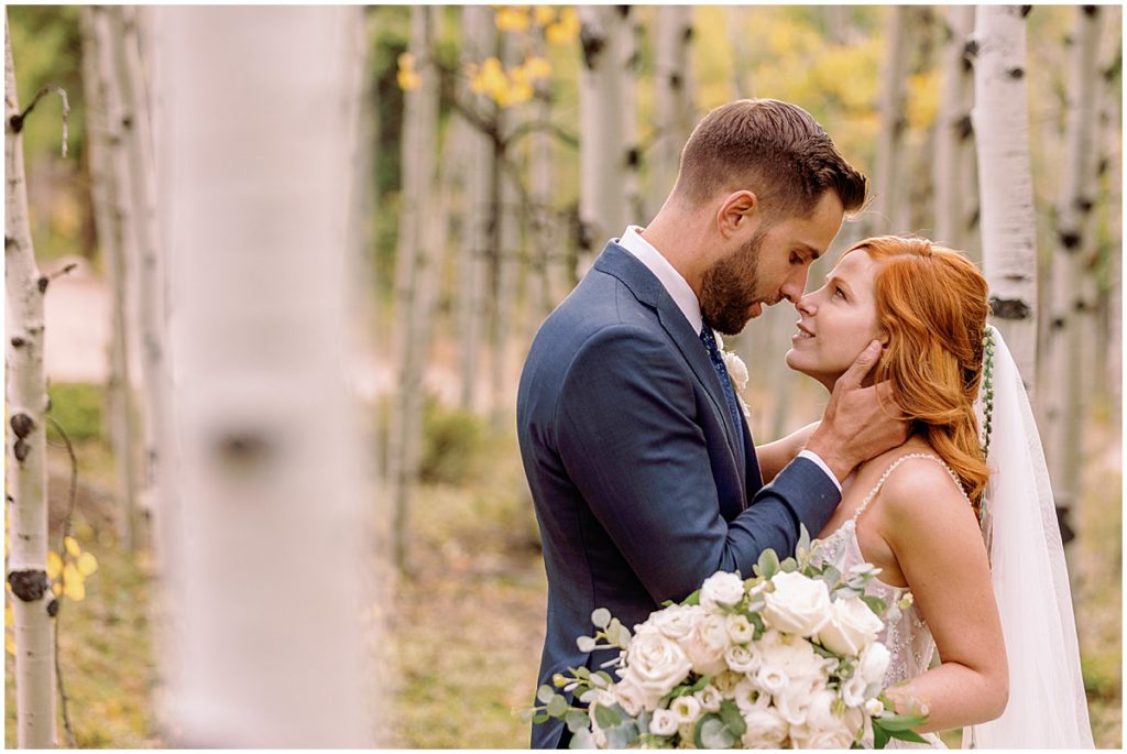 Fall elopement ceremony at Blue Sky Mountain Ranch in Blackhawk with bride wearing dress from BHLDN and designed by Watters.  Groom is wearing suit from Indochino.  Bride holding bouquet designed by Blush & Bay.