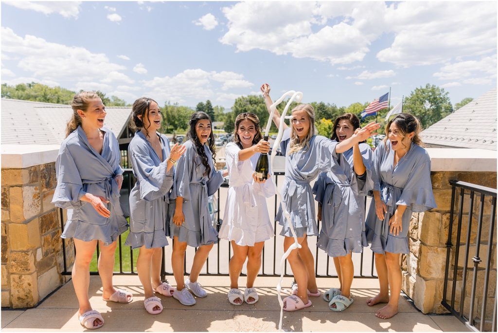 Bride and bridesmaids opening champagne at Columbine Country Club