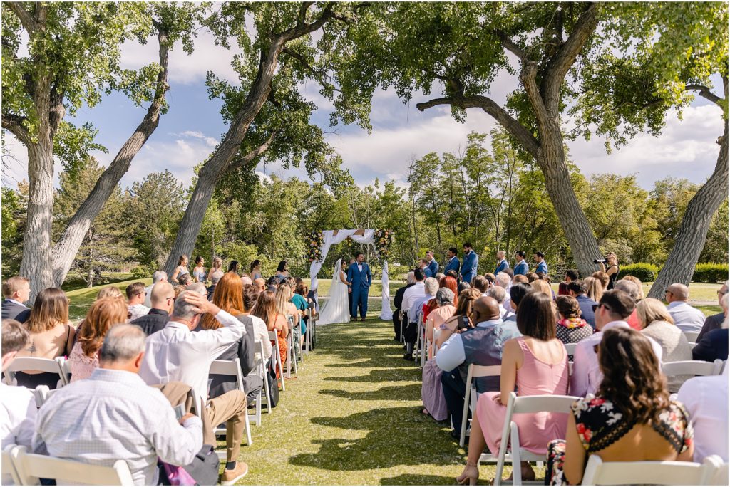 Wedding ceremony under cottonwood trees at Columbine Country Club