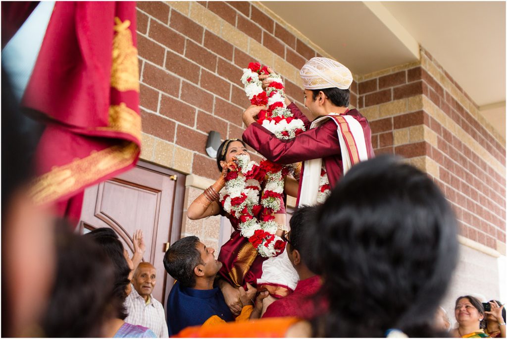 Bride and groom lifted up outside entrance at The Hindu Temple and Cultural Center of the Rockies