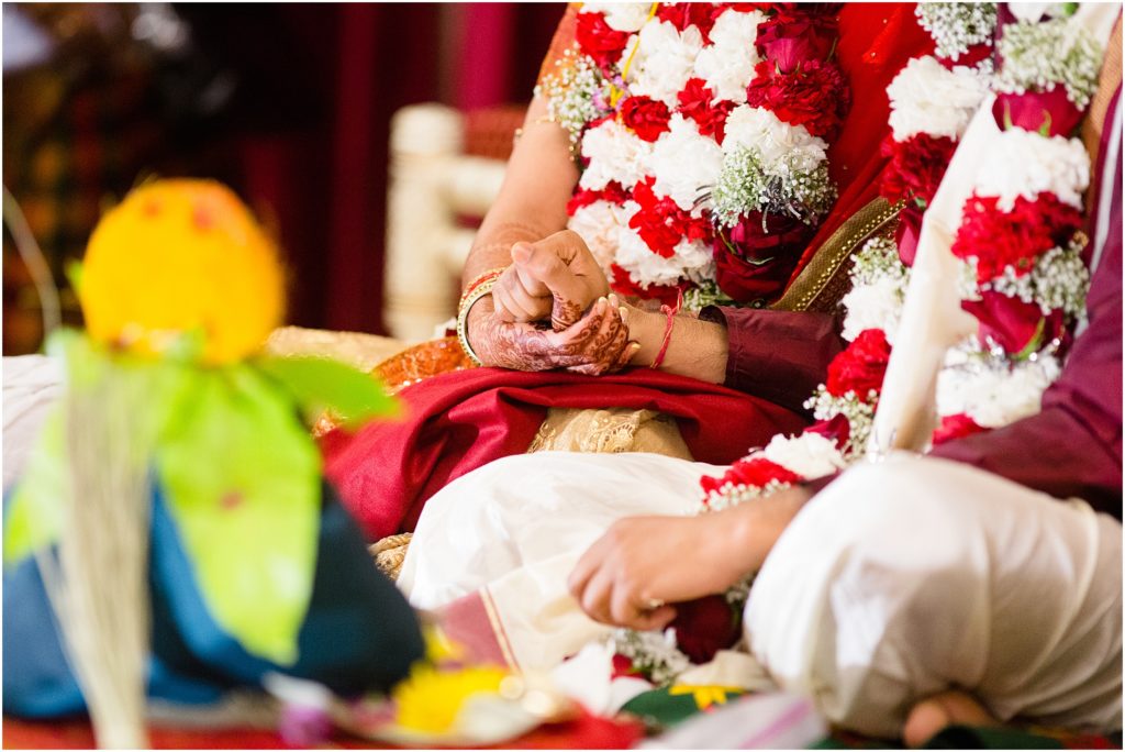 Bride and groom holding hands during ceremony at The Hindu Temple and Cultural Center of the Rockies