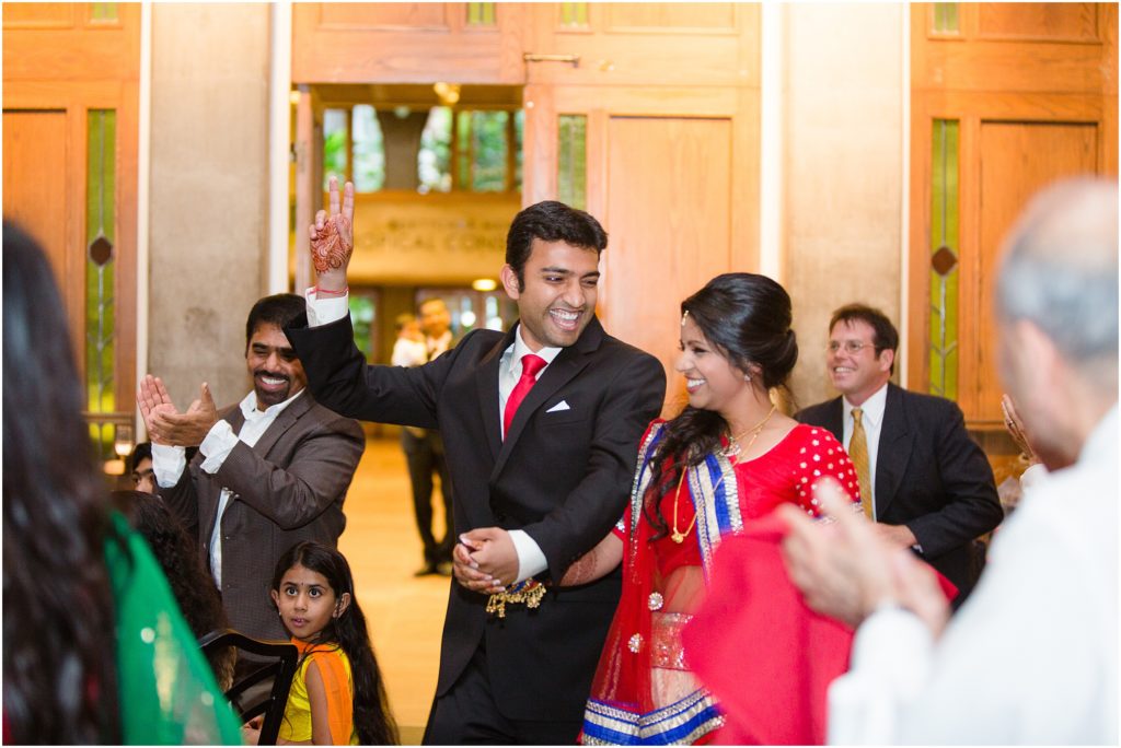 Bride and groom making grand entrance at Denver Botanic Gardens for Indian wedding reception