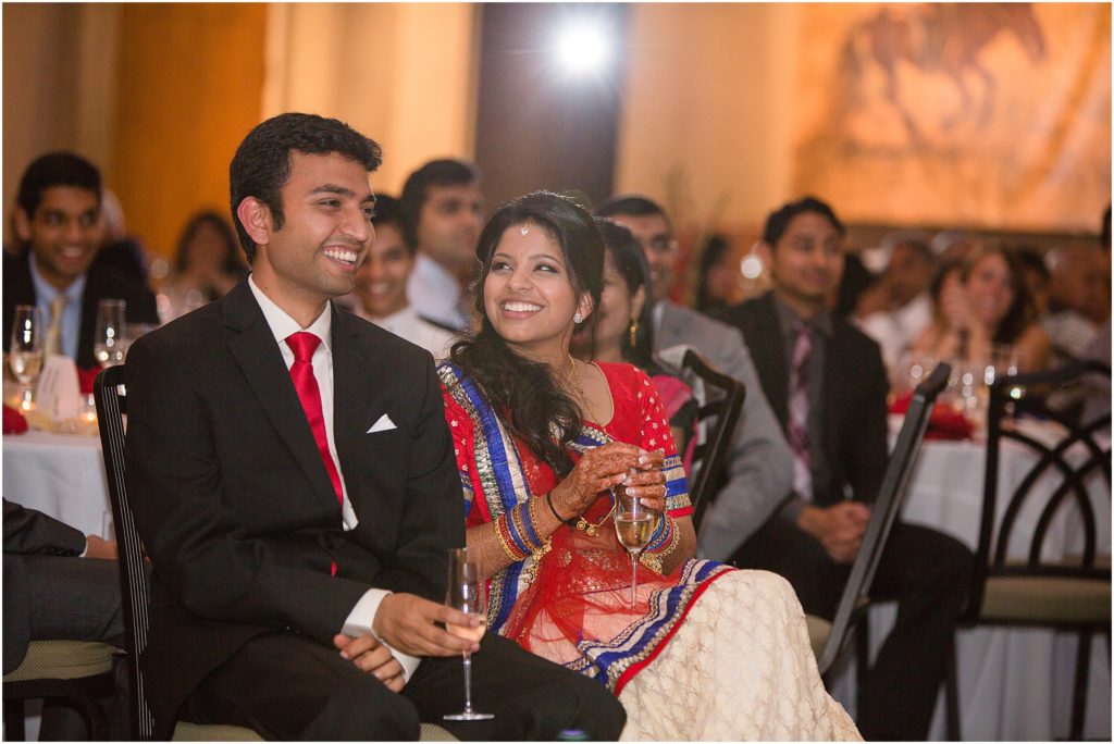Bride and groom listening to speech Denver Botanic Gardens during Indian wedding reception