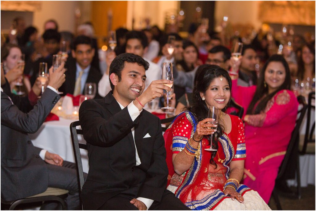 Bride and groom listening to speech Denver Botanic Gardens during Indian wedding reception