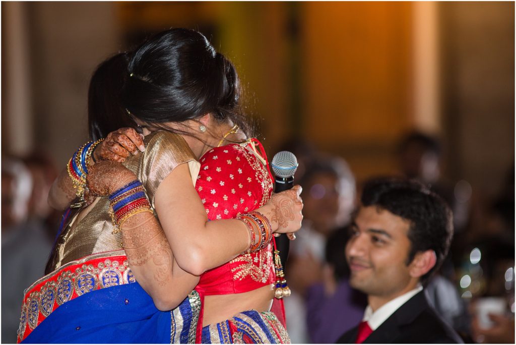 Bride hugging friend after speech at Denver Botanic Gardens during Indian wedding reception