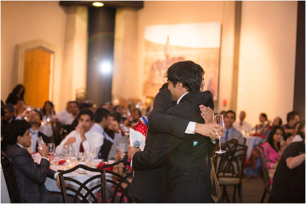 Groom hugging friend after speech Denver Botanic Gardens during Indian wedding reception
