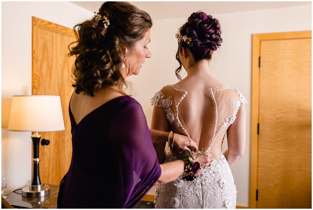 Bride getting dress on from Impression Bridal