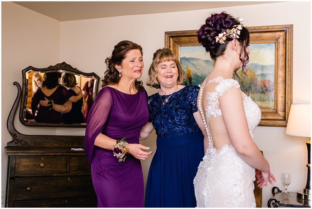 Bride getting dress on from Impression Bridal with mom