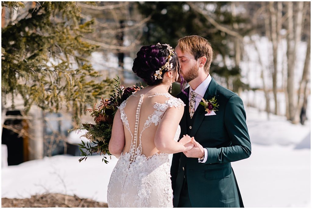 Bride and groom kiss during first look at Keystone Ranch 
