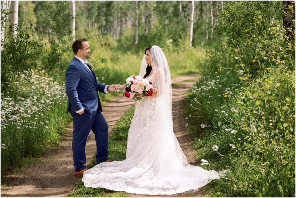 Bride and groom first look on trail at Flying Diamond Ranch in Steamboat Springs. Bride holding bouquet designed by We Plus You.