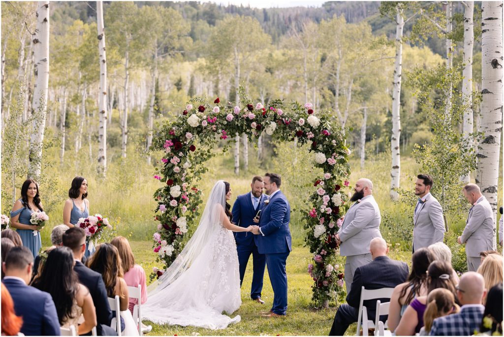 Bride and groom standing under arch designed by We Plus You at Flying Diamond Ranch in Steamboat Springs