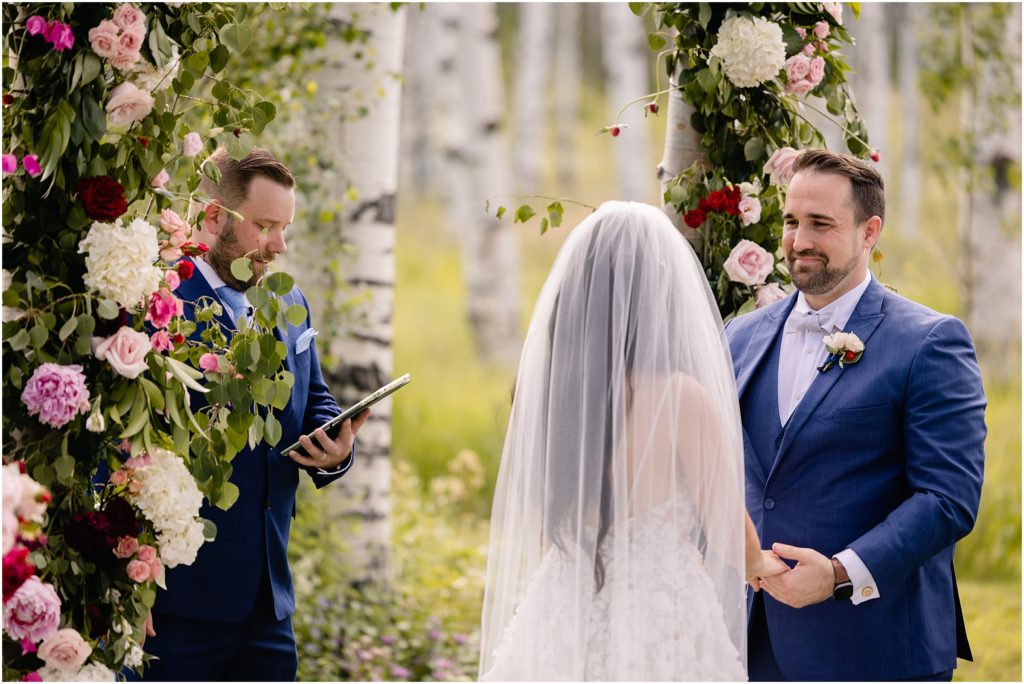 Groom looking at bride during ceremony at Flying Diamond Ranch in Steamboat Springs