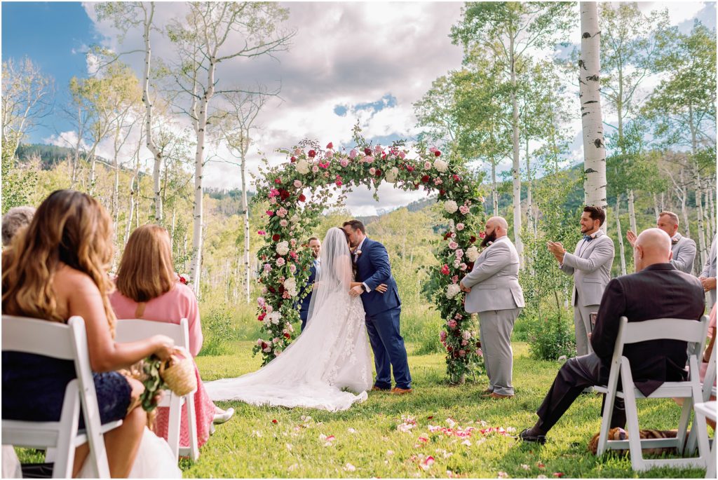 Bride and groom kiss at end of wedding ceremony at Flying Diamond Ranch in Steamboat Springs