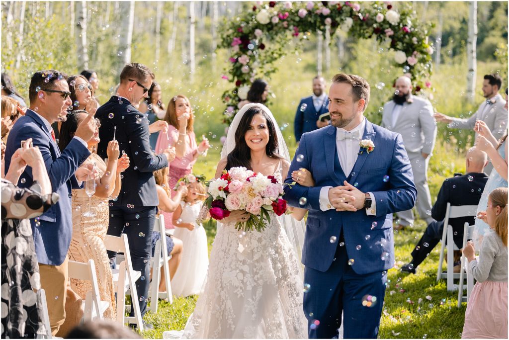 Guests blowing bubbles at end of wedding ceremony at Flying Diamond Ranch in Steamboat Springs