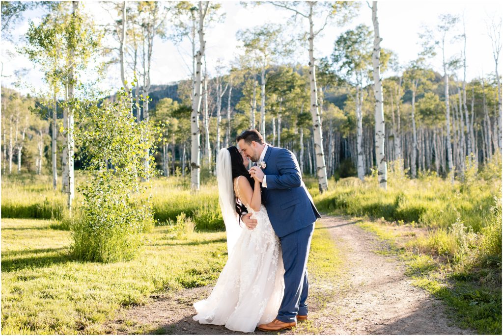 Bride and groom under aspen trees after wedding ceremony at Flying Diamond Ranch in Steamboat Springs