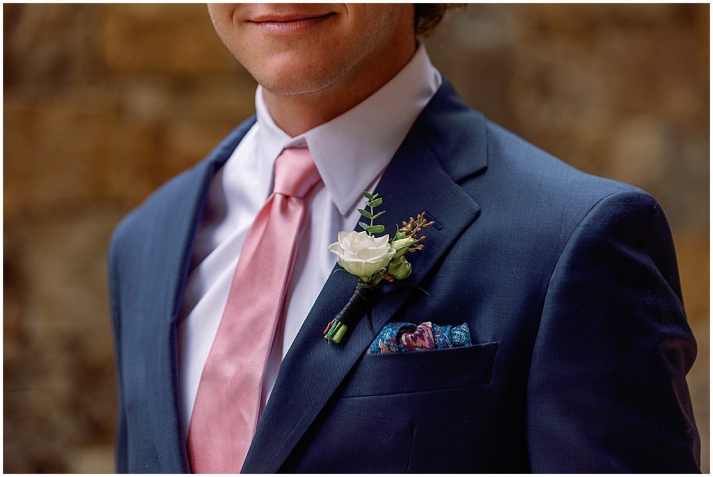 Groom wearing Jos A Bank suit with boutonniere designed by Fancy Pansy