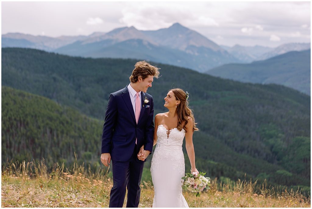 Bride and groom at top of Vail mountain.  Bride holding bouquet designed by Fancy Pansy.